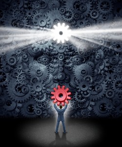 Leadership support concept as a businessman holding the missing key cog to a large corporation as a group of gears shaped as a human face as a symbol and metaphor for workers contributing new business ideas and innovative content.